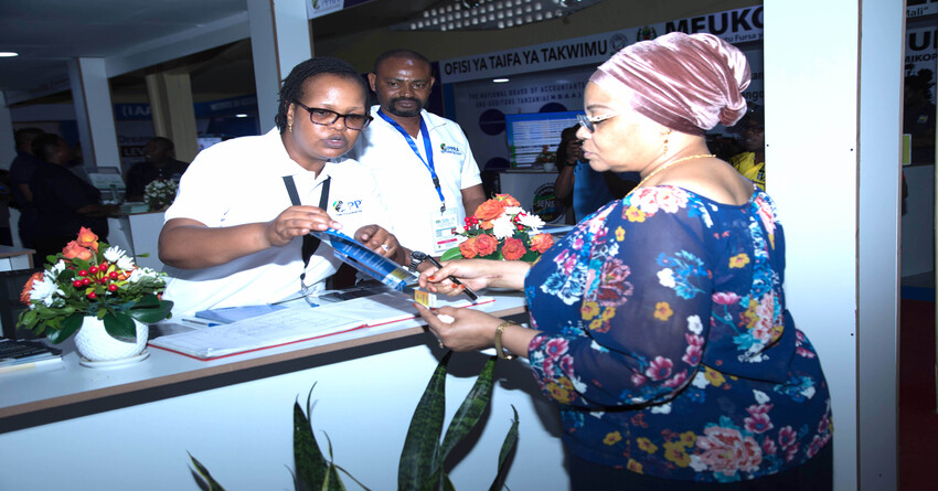 Permanent Secretary to the Ministry of Finance, Dr. Natu Wl-maamry Mwamba, listens to PPRA Public Relations Manager, Zawadi Msalla, on the new e-procurement system named NeST, when she visited the Authority’s booth at the 2023 Sabasaba Exhibition in Dar es Salaam